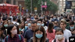 People wear masks on a street in Hong Kong, Jan. 24, 2020.