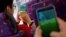 Passengers play the augmented reality mobile game "Pokemon Go" by Nintendo inside a bus in Hong Kong, China, Aug. 12, 2016. 