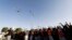 FILE - A military helicopter hovers above as followers of the Houthi movement as they demonstrate to show support to the movement in Sanaa, January 23, 2015.