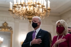 FILE - U.S. President Joe Biden, accompanied by first lady Jill Biden, places his hand over his heart during a virtual Presidential Inaugural Prayer Service in the State Dinning Room of the White House, in Washington, Jan. 21, 2021.