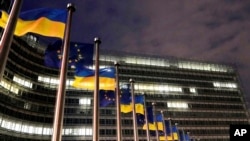 European Union and Ukrainian flags flap in the wind to mark the third anniversary of Russia's full-scale invasion of Ukraine outside EU headquarters in Brussels, Feb. 24, 2025.