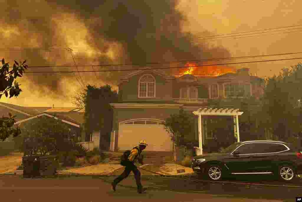 Una residencia arde mientras un bombero lucha contra el incendio de Palisades en el vecindario de Pacific Palisades de Los Ángeles, el 7 de enero de 2025.