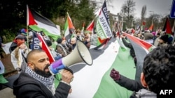 FILE - Palestinian sympathizers take part in a demonstration during a hearing at the International Court of Justice on a genocide complaint by South Africa against Israel, in The Hague, on January 11, 2024.