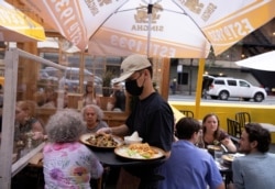 FILE - Food is served to guests at a restaurant in Manhattan, New York, August 3, 2021.