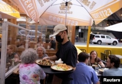 FILE - Food is served to guests at a restaurant in Manhattan, New York, August 3, 2021.
