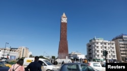 Des voitures et des gens passent devant la tour de l'horloge au bout de l'avenue Habib Bourguiba à Tunis, Tunisie le 12 mars 2020. REUTERS / Zoubeir Souissi