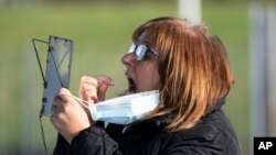 ইংল্যান্ডের লিভারপুলে কোভিড টেস্টের জন্য মুখের লালা সংগ্রহ করছেন একজন মহিলা 