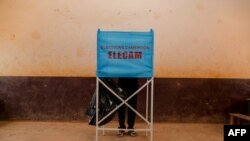FILE - A man is seen at a voting booth during general and municipal elections in Yaounde, Cameroon, Feb. 9, 2020. The country held its first regional elections Sunday.