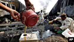 Villagers collect oil leaked from NATO trucks torched by gunmen in Khairabad near Peshawar, Pakistan, 07 Oct. 2010