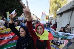 Kurdish and Arab protesters chant slogans against Turkish President Tayip Erdogan as they march to the United Nations Headquarters in Qamishli, Syria, Oct. 23, 2019.