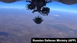 FILE - An image grab made from a video released Oct. 5, 2015, by the Russian Defense Ministry reportedly shows a Russian aircraft dropping bombs during an airstrike against Islamic State group's positions at an undisclosed location in Syria. 