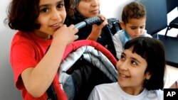 Amal Ismail eight year old (l) with her older sister Alaa (r) and their younger 18-month-old Aryam are seen by their mother Maha at the IOM 'International Organization for Migration' office in capital Nicosia, Cyprus, March 22, 2016.