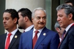 FILE - Khalifa Haftar, center, the military commander who dominates eastern Libya, leaves after an international conference on Libya at the Elysee Palace in Paris, May 29, 2018.