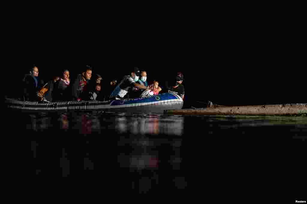 En medio de la oscuridad de la noche, la balsa inflable en la que atraviesan los migrantes el R&#237;o Grande toca tierras texanas. 