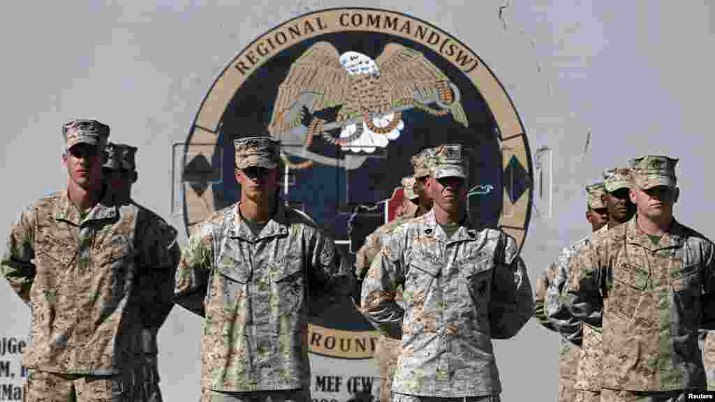 U.S. Marines stand at attention during a handover ceremony, as the last U.S. Marines unit and British combat troops end their Afghan operations, in Helmand province, Oct. 26, 2014. 