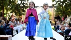 Young models wear two of 2014's hottest Halloween costumes, (from left) Anna and Elsa from Disney's "Frozen" at a Disney Halloween Fashion Show on Oct. 1, 2014, in Glendale, Calif.