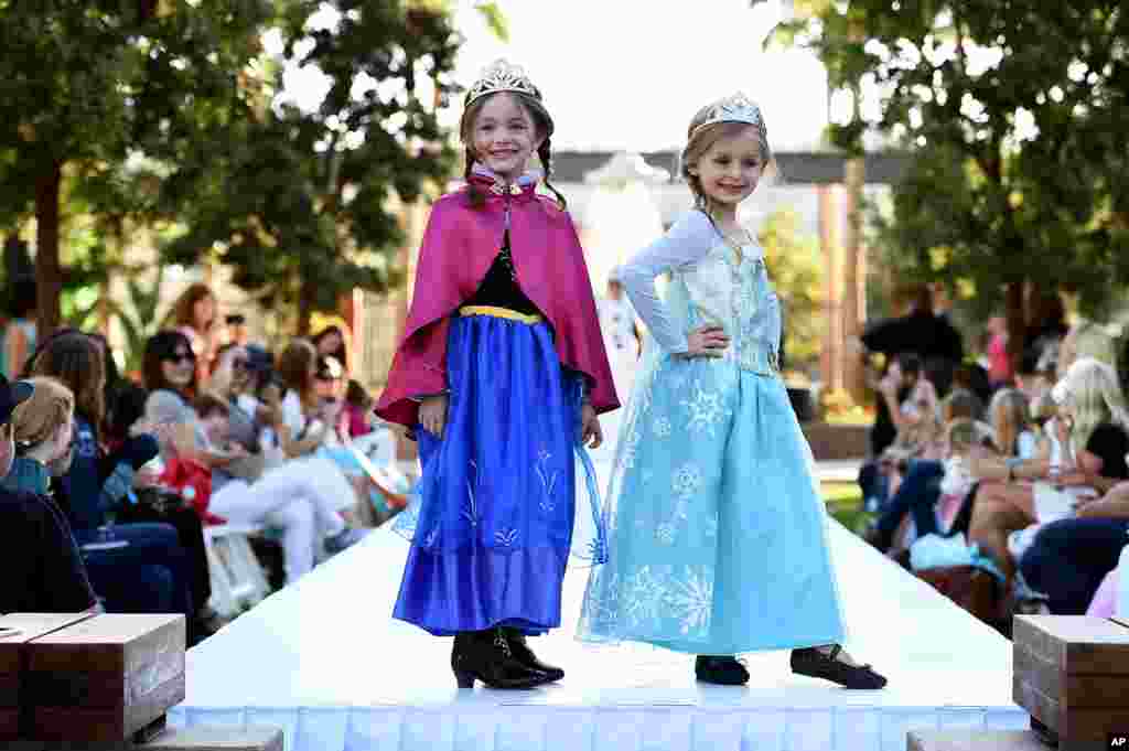 Young models wear two of 2014's hottest Halloween costumes, (from left) Anna and Elsa from Disney's "Frozen" at a Disney Halloween Fashion Show on Oct. 1, 2014, in Glendale, Calif.