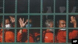 Cambodian prisoners on a prisoner truck arrive at the Phnom Penh Municipal Court in Phnom Penh, Cambodia, Wednesday, Nov. 17, 2021. (AP Photo/Heng Sinith)