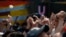 People raise their hands in protest and remembrance during the one year anniversary of the 7.1 earthquake, at the Multifamiliar de Tlalpan, in Mexico City, Sept. 19, 2018. 