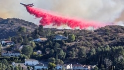 Sebuah tanker udara menjatuhkan bahan kimia anti api di Palisades Fire, salah satu kebakaran beruntun yang melanda Los Angeles County, seperti terlihat dari Woodland Hills, kawasan Los Angeles, California, AS, 11 Januari 2025. (Foto: Ringo Chiu/Reuters)