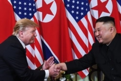 S President Donald Trump (L) shakes hands with North Korea's leader Kim Jong Un following a meeting at the Sofitel Legend Metropole hotel in Hanoi on February 27, 2019. (Photo by Saul LOEB / AFP)