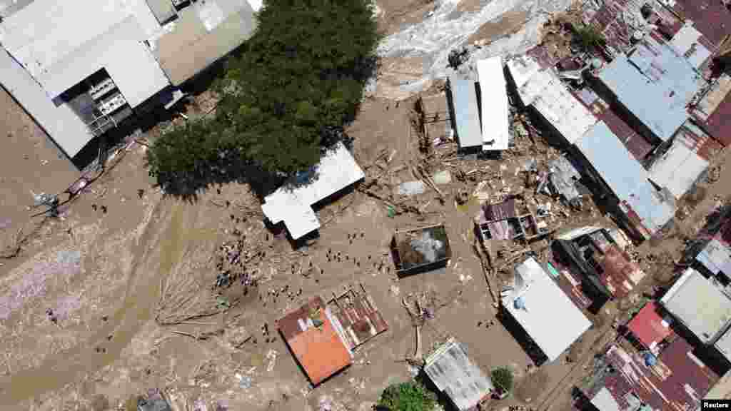 Los lugareños esperan ayuda luego de un deslizamiento de tierra debido a las fuertes lluvias.