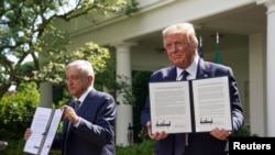 U.S. President Donald Trump holds a joint declaration he signed with Mexico's President Andres Manuel Lopez Obrador in the Rose Garden at the White House in Washington, July 8, 2020.