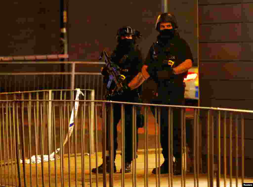 Armed police officers stand next to a police cordon outside the Manchester Arena, where U.S. singer Ariana Grande had been performing, in Manchester, northern England, Britain, May 23, 2017. 