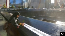 Khudeza Begum traces the name of her slain nephew on the 11th anniversary of the terrorist attacks on the World Trade Center in New York. Begum lost her nephew, Nural Miah, and his wife, Shakila Yasmin, in the attacks on Sept. 11, 2001. 