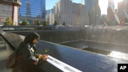 Khudeza Begum traces the name of her slain nephew on the 11th anniversary of the terrorist attacks on the World Trade Center in New York. Begum lost her nephew, Nural Miah, and his wife, Shakila Yasmin, in the attacks on Sept. 11, 2001. 