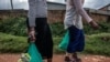 FILE - Sex workers walk home after receiving aid during a lockdown to fight COVID-19 in Kampala, Uganda, May 7, 2020. A bill passed in the first week of May 2021 would enshrine criminalization of same-sex relations, sex work and those living with HIV. 