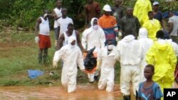 Rescue workers carry the body of a victim from the site of a mudslide in Regent, east of Freetown, Sierra Leone, Aug. 14, 2017. 