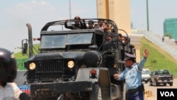 Traffic police directs traffic for a truck that carry police securities near Phnom Penh Municiple Court on April 8th, 2015. (Nov Povleakhena/VOA Khmer)