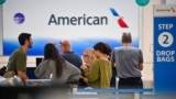 Pasagjerët presin në aeroportin e San Juan, në Puerto Rico më 24 dhjetor, 2024, ndërkohë që kompania ajrore "American Airlines" nisi fluturimet pas një ndalese një orëshe për shkak të një problemi teknik në sistemin e saj/Reuters