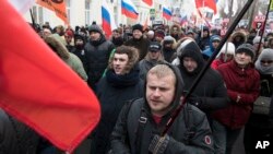 Les Russes, avec des drapeaux de différents mouvements d'opposition, marchent à la mémoire du chef de l'opposition Boris Nemtsov à Moscou, en Russie, le dimanche 25 février 2018.