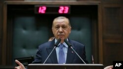 Turkey's President Recep Tayyip Erdogan gesture as he delivers a speech to members of his ruling Justice and Development (AKP) Party, during its weekly meeting in Ankara, Turkey, May 8, 2018. 