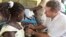 FILE - GAVI chief Seth Berkley inoculates a child with a Rotavirus vaccine at the in the village of Nkyenoa, Ghana, April 27, 2012.