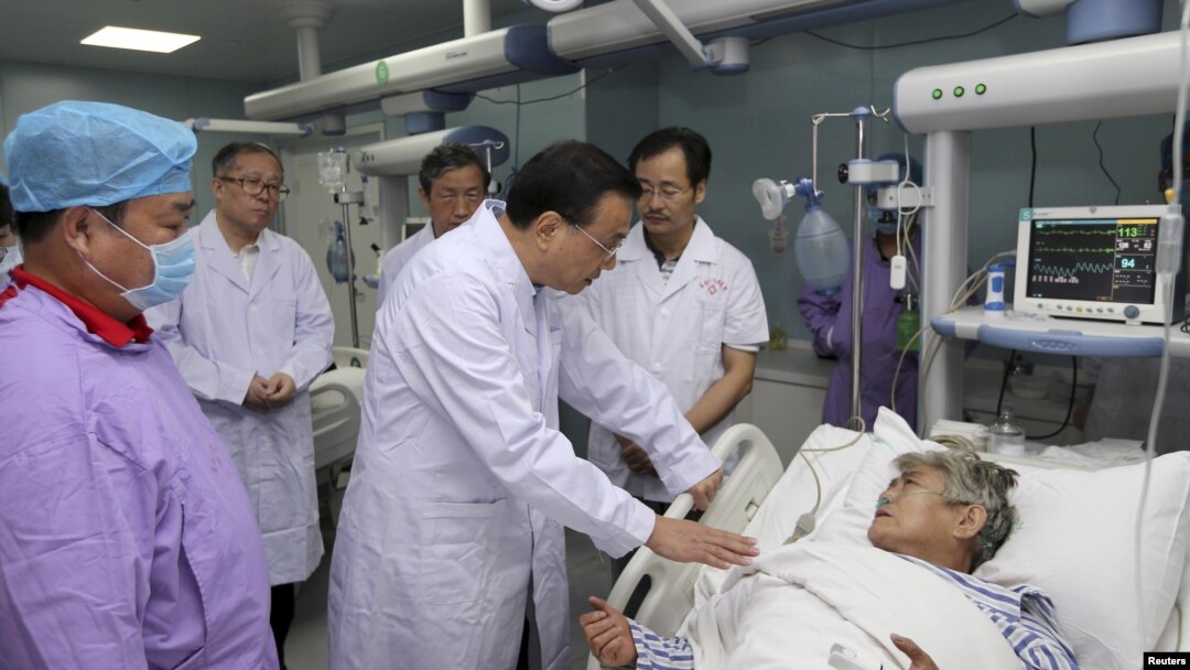 El premier chino, Li Keqiang, habla con una sobreviviente del naufragio en el río Yangtzé en un hospital de Jianli, provincia Wuhan.