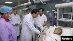 El premier chino, Li Keqiang, habla con una sobreviviente del naufragio en el río Yangtzé en un hospital de Jianli, provincia Wuhan.