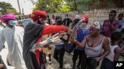 Un líder comunitario distribuye machetes entre la población en una iniciativa para resistir a las pandillas que buscan controlar su vecindario en el distrito de Delmas de Puerto Príncipe, Haití, el 13 de mayo de 2023.