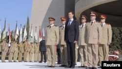 President Bashar al-Assad stands with his military generals, most of whom are Alawites, at the Tomb of the Unknown Soldier in Damascus, October 6, 2011 