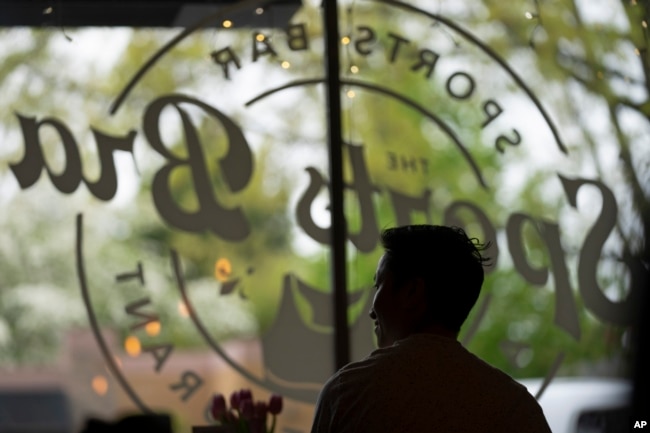 The Sports Bra founder and CEO Jenny Nguyen looks towards the door as a customer enters at the sports bar on Thursday, April 25, 2024, in Portland, Ore. (AP Photo/Jenny Kane)