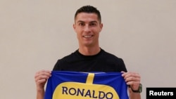 Mchezaji wa soka wa Ureno Cristiano Ronaldo akiwa ameshikilia shati ya klabu ya Al-Nassr ya Saudia Arabia baada ya kusaini mkataba wa kihistoria katika soka la Mashariki ya Kati. REUTERS.
