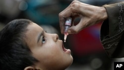 FILE - A health worker administers a polio vaccine to a child in a neighborhood of Karachi, Pakistan, on Jan. 8, 2024.