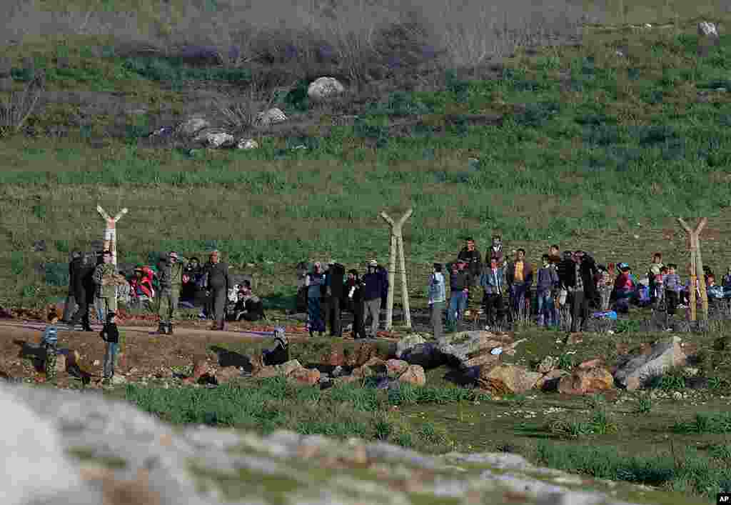 Syrians, fleeing violence in their country, wait inside Syria to enter Turkey near Reyhanli, Turkey, March 19, 2012. (AP)