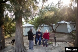 ساکنان روستای وکیفلی در باغ بیرون از یک چایخانه جلوی چادرهایشان نشسته‌اند - ۲۴ فوریه ۲۰۲۳