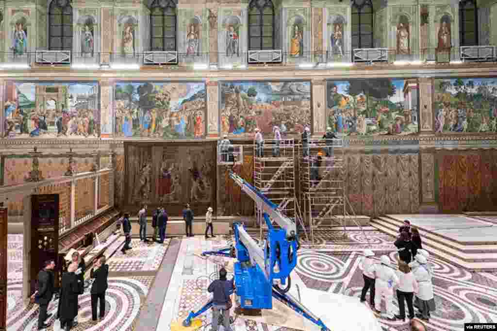 A tapestry designed by Renaissance artist Raphael is installed on a lower wall of the Sistine Chapel at the Vatican as part of celebrations marking the 500th anniversary of his death in this handout photo released.