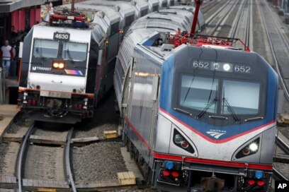 Kereta Amtrak melewati kereta New Jersey Transit yang berhenti untuk menurunkan dan menaikkan penumpang di stasiun kereta Elizabeth di Elizabeth, N.J., di sepanjang Koridor Timur Laut Amtrak, 12 Maret 2016.(Foto: AP)