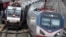 FILE - An Amtrak train passes a New Jersey Transit train stopped to discharge and board passengers at Elizabeth train station in Elizabeth, N.J., along Amtrak's Northeast Corridor, March 12, 2016, 