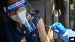 Un médico inmuniza a una mujer con una dosis de la vacuna Sputnik V durante una campaña de vacunación para ancianos, en el hotel Alba Caracas, el 29 de mayo de 2021.